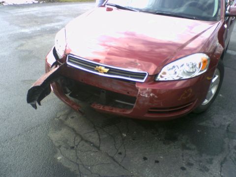 1995 Ford Bronco - Front view of a damaged red Chevrolet Impala, showing a broken bumper and fender.