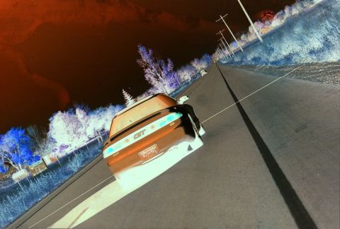 1996 Ford Probe - A car with a GT badge is seen from behind on a road with trees and power lines.