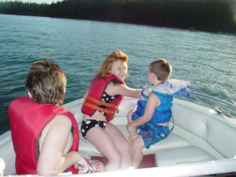 1986 Ford Bronco - Children enjoy a boat ride on the water, wearing life vests for safety.