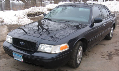 1999 Ford Crown Victoria - Dark blue Ford Crown Victoria parked on asphalt with snow in the background.