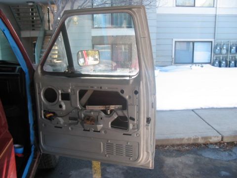 1991 Ford Bronco - The interior door panel of a vehicle has been removed, exposing the internal components and wiring.