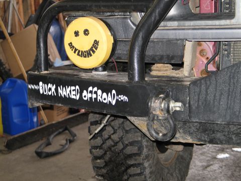 1995 Ford Bronco - Close-up of a black steel front winch bumper with tubular pre-runner hoop, lettered 'www.BUCK NAKED offROAD.com' across the face and fitted…