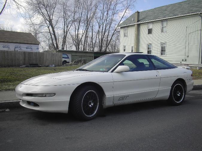 White 1996 Ford Probe coupe with black rims parked on street
