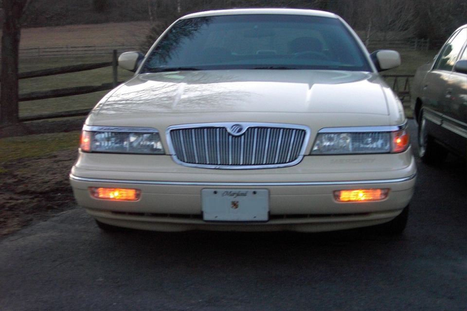 Front of a cream Mercury Grand Marquis showing waterfall grille, Mercury emblem, and Maryland plate