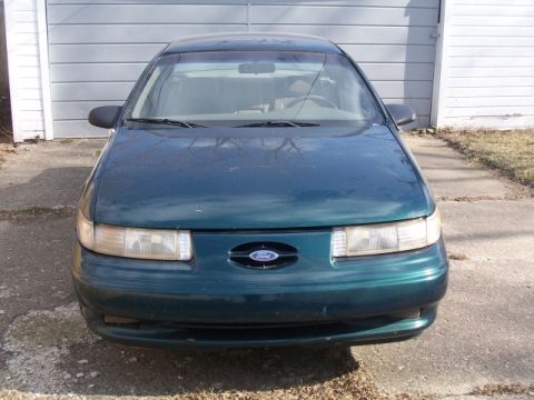 1993 Ford Taurus - The front of a green 1992 Ford Taurus is visible, parked on a concrete driveway.