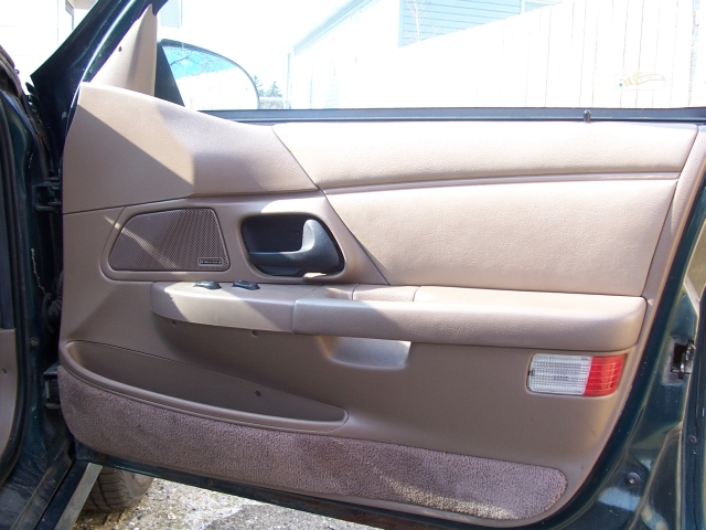 1993 Ford Taurus interior door panel with speaker grille and window controls