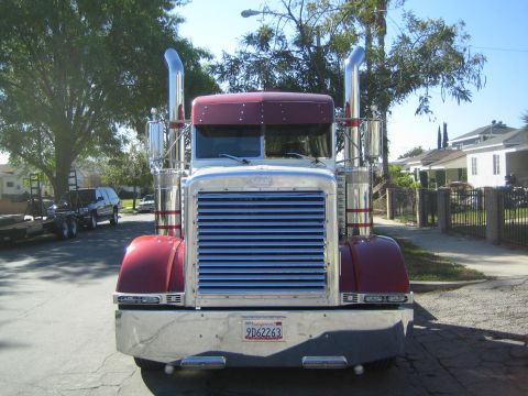 1968 Ford Mustang - A large semi-truck is parked on a residential street under a clear blue sky.