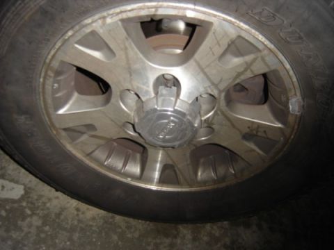 1999 Ford Taurus - Close-up of a vehicle's wheel and tire assembly, showing the alloy wheel and tire tread.