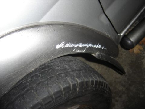 1999 Ford Taurus - Scratches are visible on the silver fender above the tire of this vehicle.