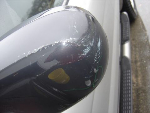 1999 Ford Taurus - Scratched side mirror with visible damage and some attached components.