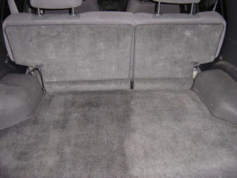 1999 Ford Taurus - The gray carpeted cargo area shows folded rear seats and the interior of the vehicle.