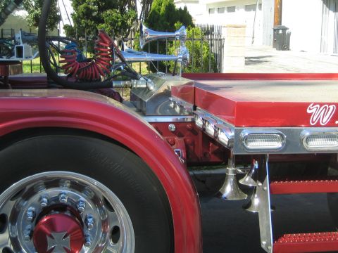 1968 Ford Mustang - A close-up view of a red semi-truck's side, chrome air horns and a large tire with a decorative hubcap.