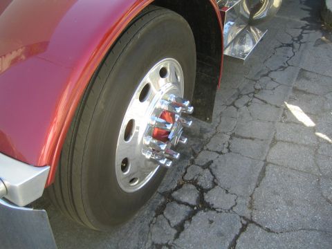 1968 Ford Mustang - A close-up view of a large truck's wheel and part of its red fender.