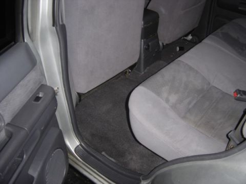 1999 Ford Taurus - Rear interior of a vehicle showing the seats, door panel, and floor carpet.