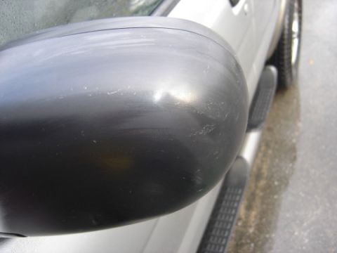 1999 Ford Taurus - Side mirror and running boards on a silver vehicle.