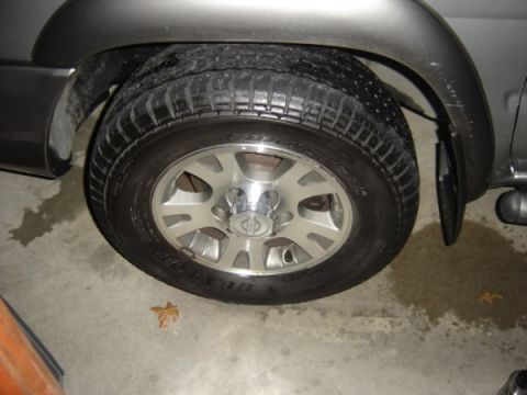 1999 Ford Taurus - A close-up view of a vehicle's wheel and tire, showing the tread pattern and alloy rim.