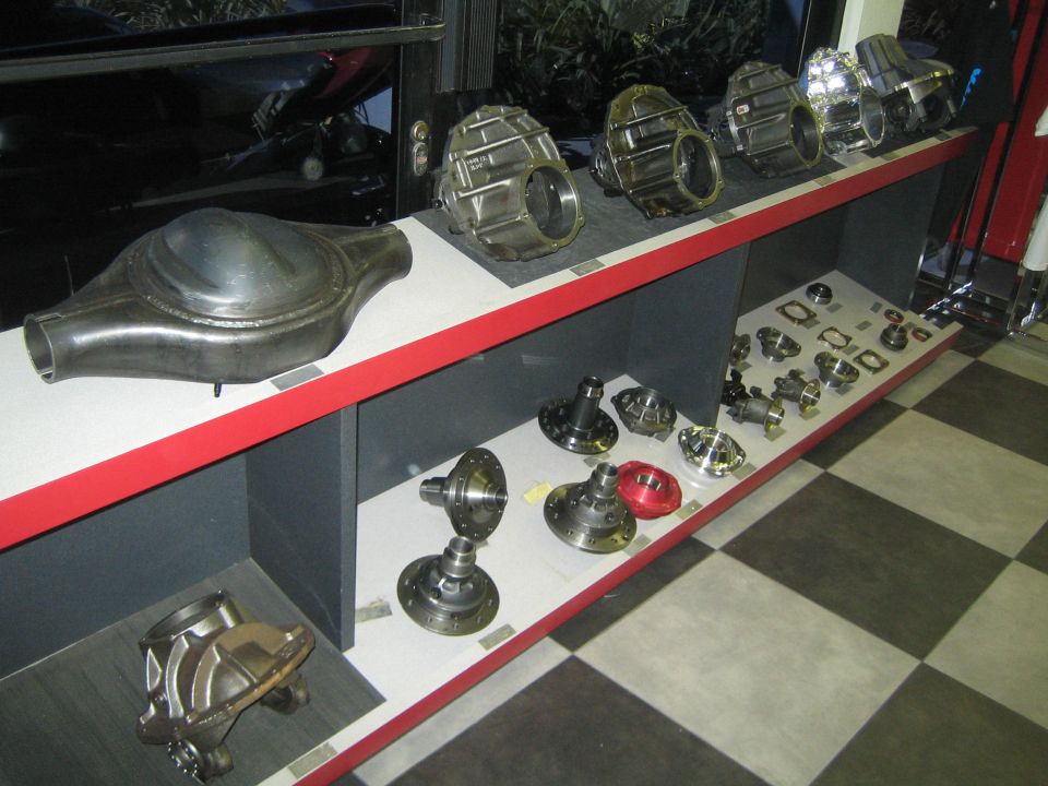 Differential housings and gear parts displayed on a red-trimmed shelf