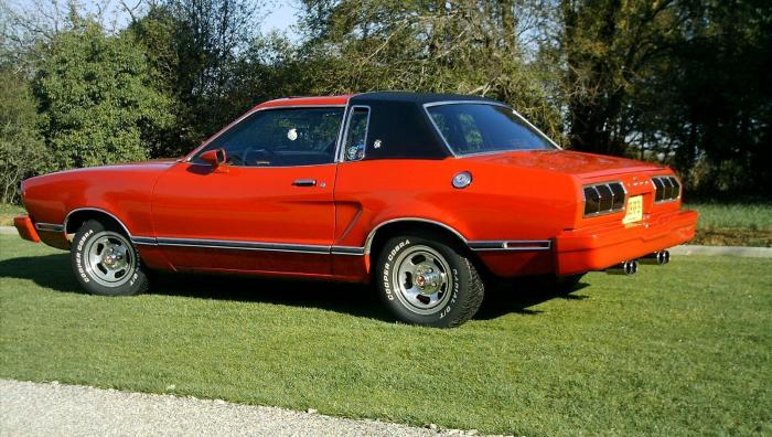 1978 Ford Mustang II coupe, red with black vinyl top, parked on grass