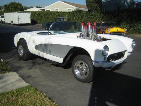 1968 Ford Mustang - A white convertible with a prominent exposed engine and multiple exhaust pipes is parked on a driveway, with another car in the background.