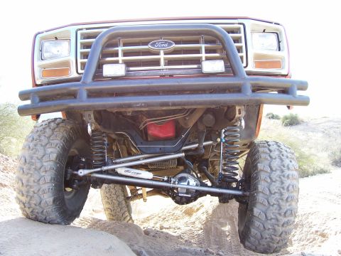 1984 Ford Bronco - This modified Ford Bronco shows its lifted suspension and off-road tires from a low front angle.