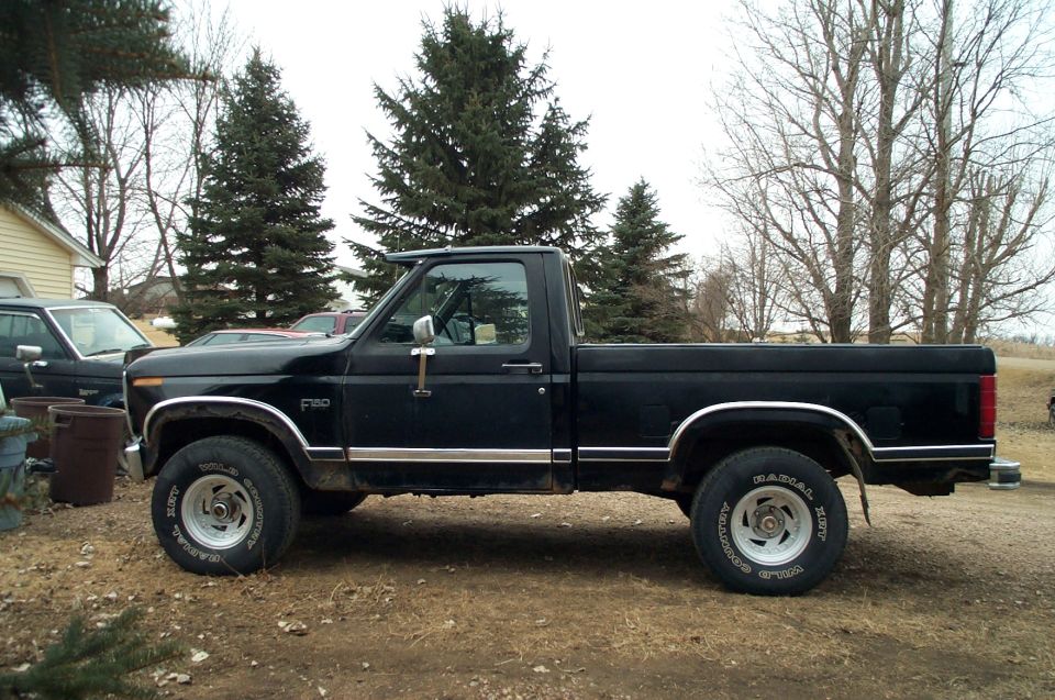Black pickup truck parked outdoors, side view. F-150 badge visible on fender
