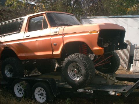 1978 Ford Bronco - 1978 Ford Bronco on a trailer, lifted with aftermarket suspension and off-road tires. Front end is missing grille.