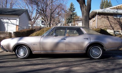 1972 Ford Ranchero - This 1970 Oldsmobile Cutlass Supreme sedan is seen from the side, parked on a residential street.