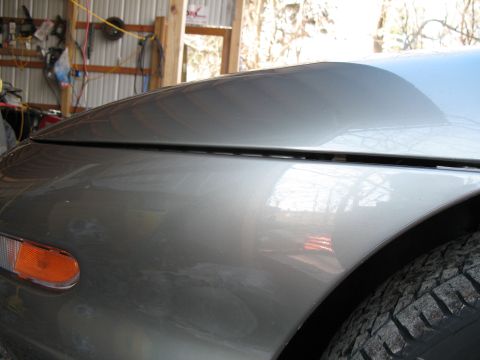 1996 Ford Probe - Close-up view of the front fender and hood of a silver car, showing the turn signal light.