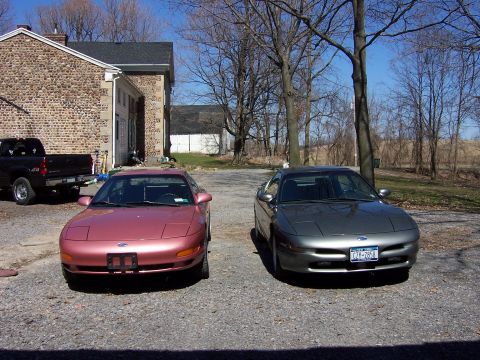 1996 Ford Probe - Two Ford Probes, a rose metallic and a gray model, are parked side-by-side in a driveway.