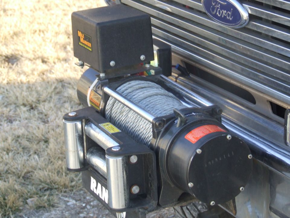 1986 Ford Bronco front grille with a Mile Marker winch installed. The Ford logo is visible above the winch