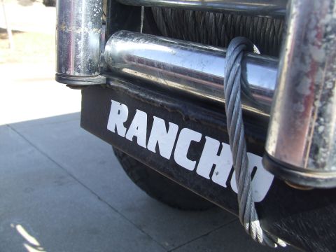 1986 Ford Bronco - A winch with a prominent "RANCH" label is mounted on a vehicle's front end.