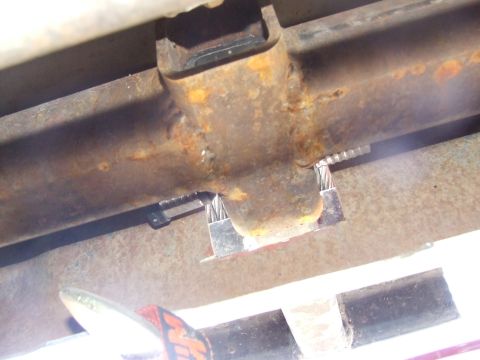 1986 Ford Bronco - Close-up of a surface-rusted boxed frame rail where a fresh weld bead joins a fabricated bracket or crossmember, with the bright new weld a…