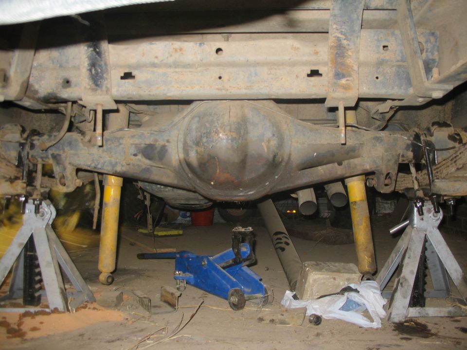 Rear axle assembly on jack stands with yellow shocks visible