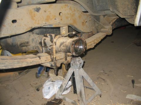 1981 Ford Bronco - The rear axle assembly of a vehicle is shown supported by jack stands, with leaf springs attached.