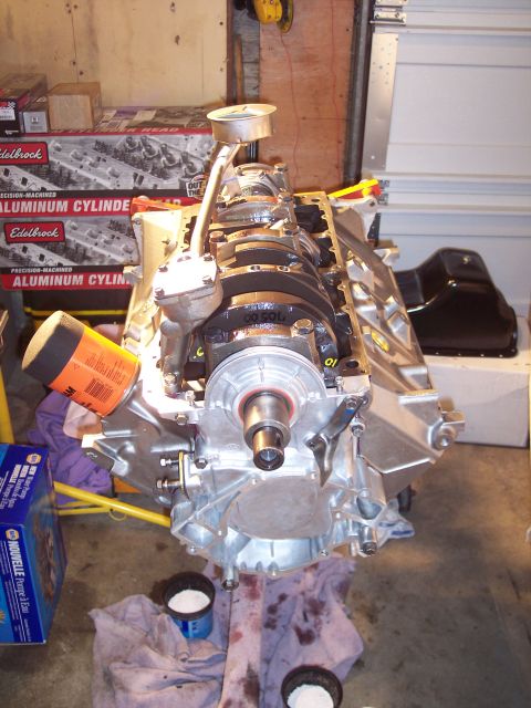 1981 Ford Bronco - Engine block assembly with oil filter and dipstick visible, surrounded by automotive parts and tools.