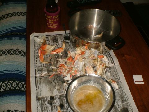 1989 Ford Bronco - A messy crab feast is laid out on a table, with shells scattered across newspaper and a bowl of melted butter.