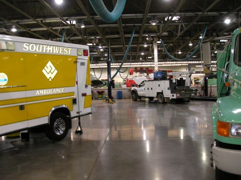 1993 Ford Bronco - An ambulance is parked inside a garage bay, with other service vehicles visible in the background.