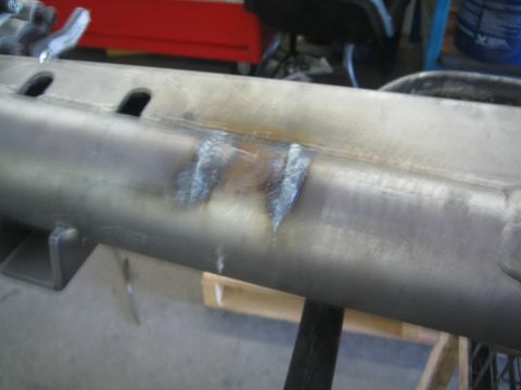 1990 Ford Bronco - close-up shows a welded build-up of bead on a bare-metal frame rail or tube resting on a shop stand.