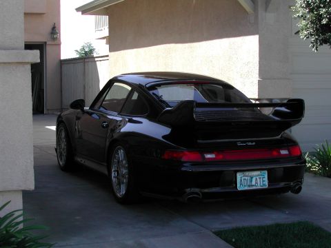 1997 Porsche 911 - Rear view of a black 1997 Porsche 911 Turbo parked in a driveway.