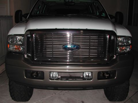 2005 Ford Excursion - The front grille and headlights of a large Ford truck are shown in this close-up photo.
