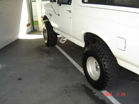 1993 Ford Bronco - This white SUV is parked in a covered area, with a focus on its side profile and tires.