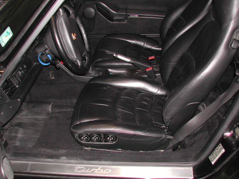 1997 Porsche 911 - Interior view of a Porsche 911, showing black leather seats and the dashboard. 'Turbo' script on the door sill.