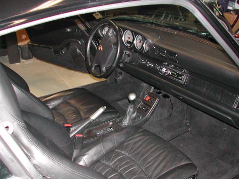 1997 Porsche 911 - The interior of a Porsche 911, black leather seats and a classic dashboard layout.
