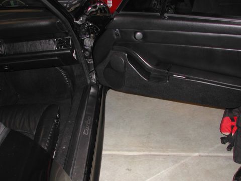 1997 Porsche 911 - The interior of a black Porsche 911 shows the door panel and dashboard, with "Turbo" lettering visible on the sill plate.