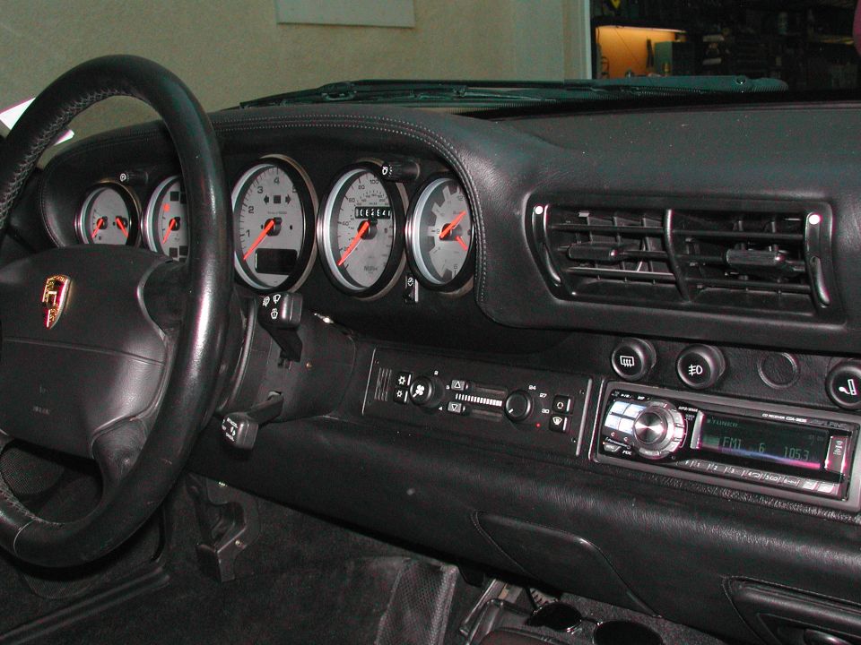 Porsche 911 black leather dash with five-gauge cluster and Alpine CD head unit