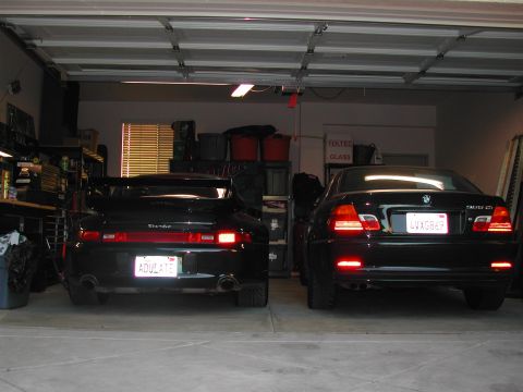1997 Porsche 911 - Rear view of a 1997 Porsche 911 and a BMW 3 Series sedan parked side-by-side in a garage.