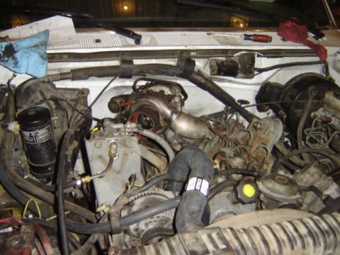 1992 Ford Bronco - Close-up view of a complex engine bay, showing a turbocharger and associated plumbing.