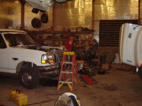 1992 Ford Bronco - A 1992 Ford Bronco is shown in a garage with its hood open, undergoing maintenance.