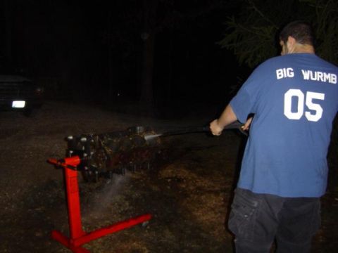 1979 Ford Bronco - A person is cleaning an engine block with a pressure washer at night. Another vehicle is visible in the background.
