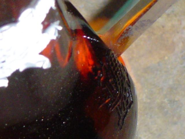 Dark red taillight lens with textured black trim and white debris